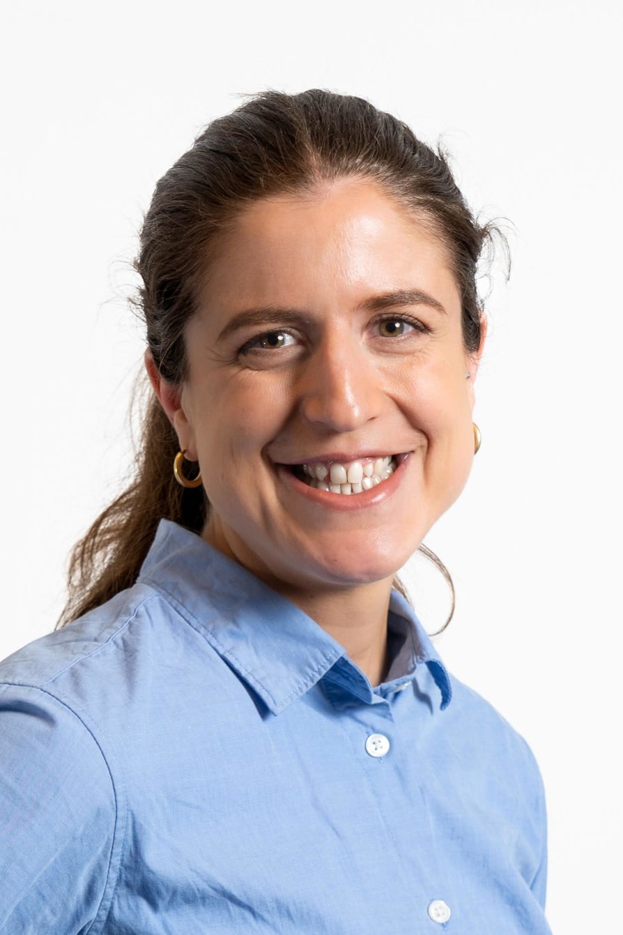Clio Heslop, Head of Policy, Partnerships and Impact; woman smiling at the camera with brown hair in a ponytail and wearing a blue collared shirt